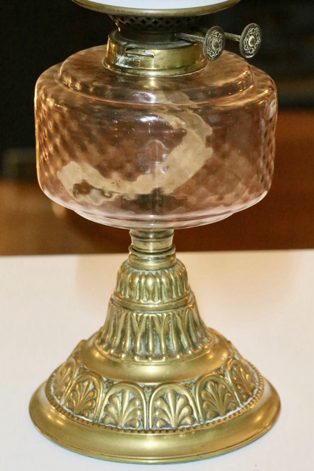 Close-up of pink glass reservoir and embossed brass column