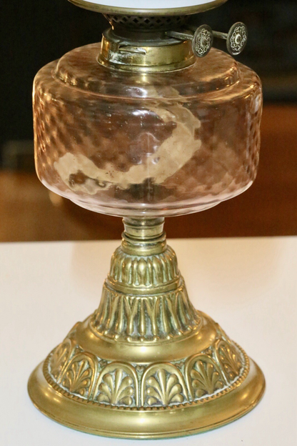 Close-up of pink glass reservoir and embossed brass column