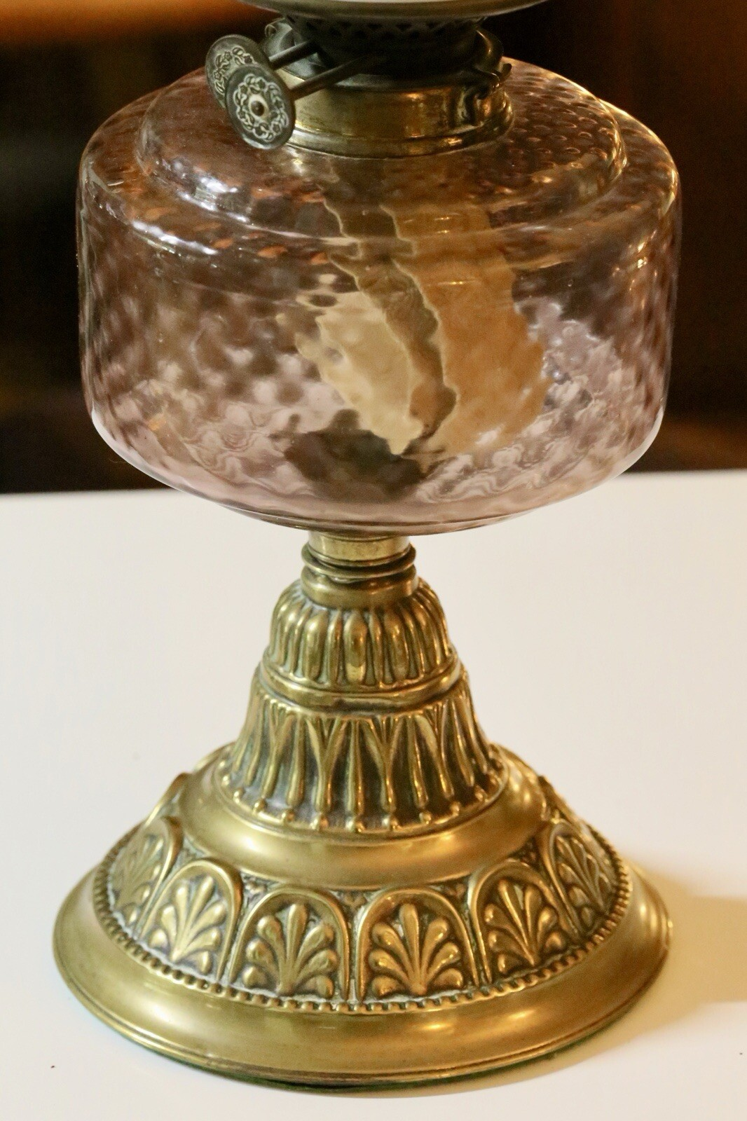 Close-up of pink diamond-pattern glass reservoir on brass base