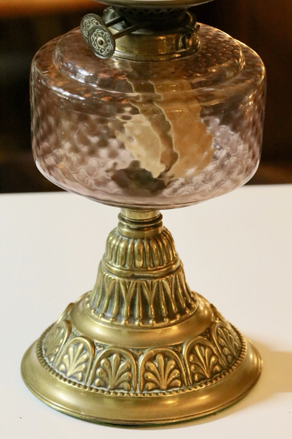 Close-up of pink diamond-pattern glass reservoir on brass base