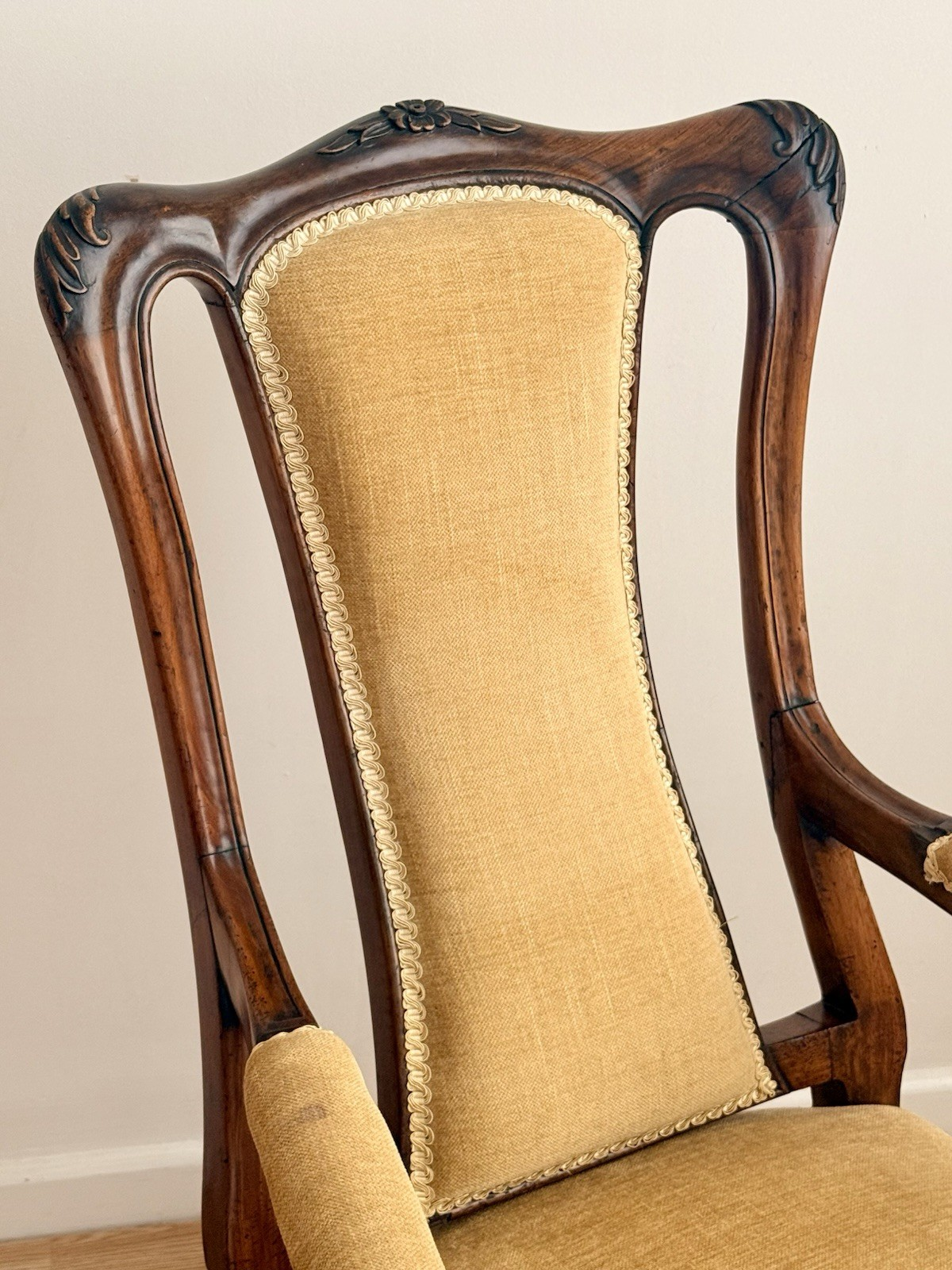 Close-up of carved crest rail and upholstered back panel