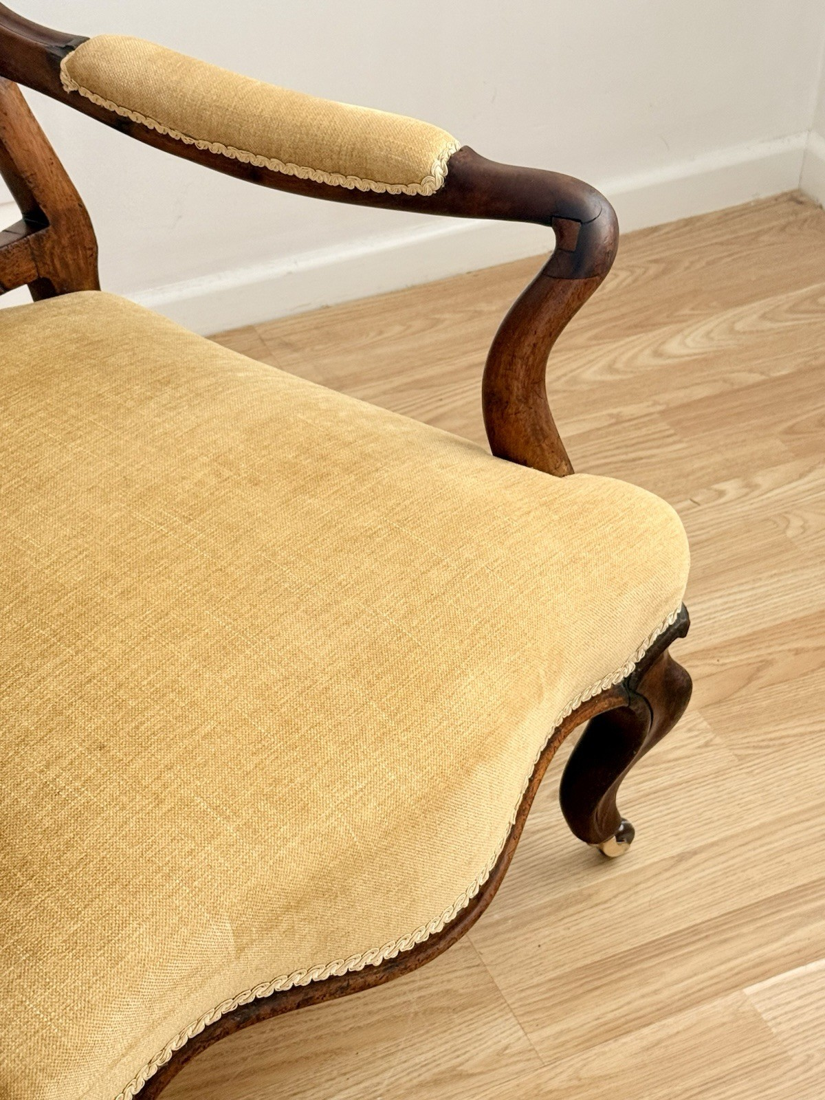 Close-up of scrolled rosewood arm and seat