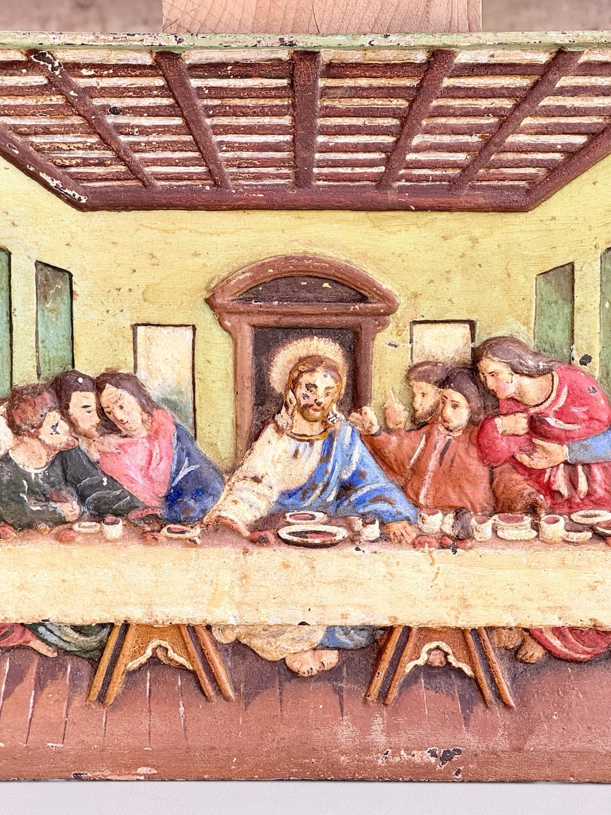 Close-up of Christ at the centre of the Last Supper relief plaque
