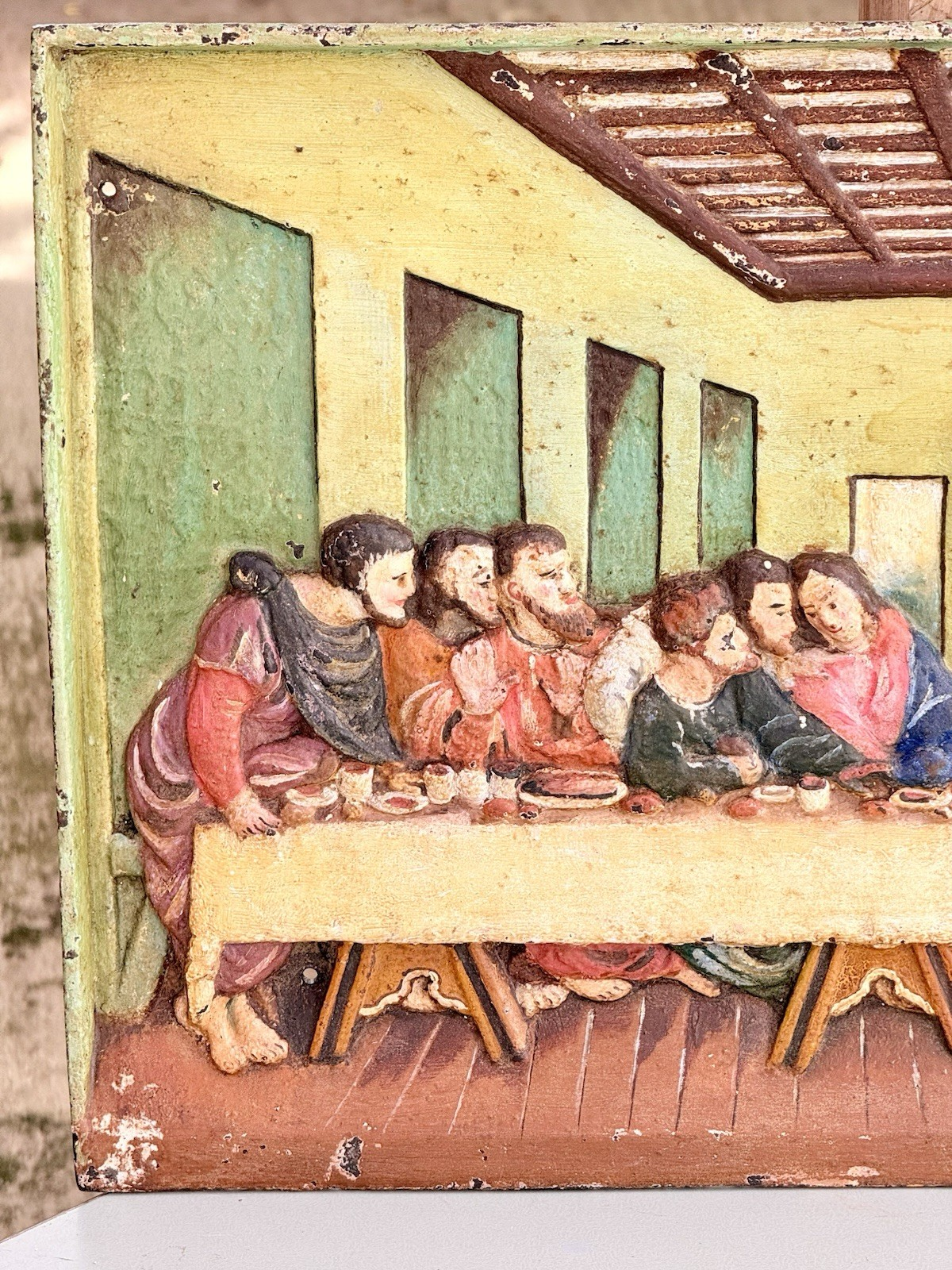 Close-up of painted apostles on the right of the cast iron plaque