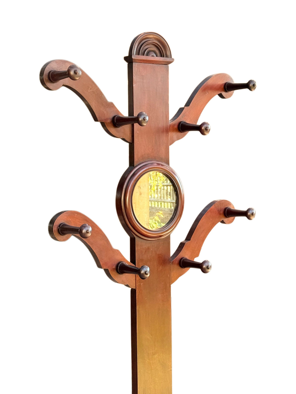 Top of the Victorian mahogany hall stand: lunette crest, S-scroll arms with turned pegs and circular mirror
