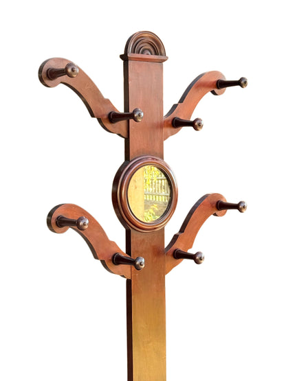 Top of the Victorian mahogany hall stand: lunette crest, S-scroll arms with turned pegs and circular mirror