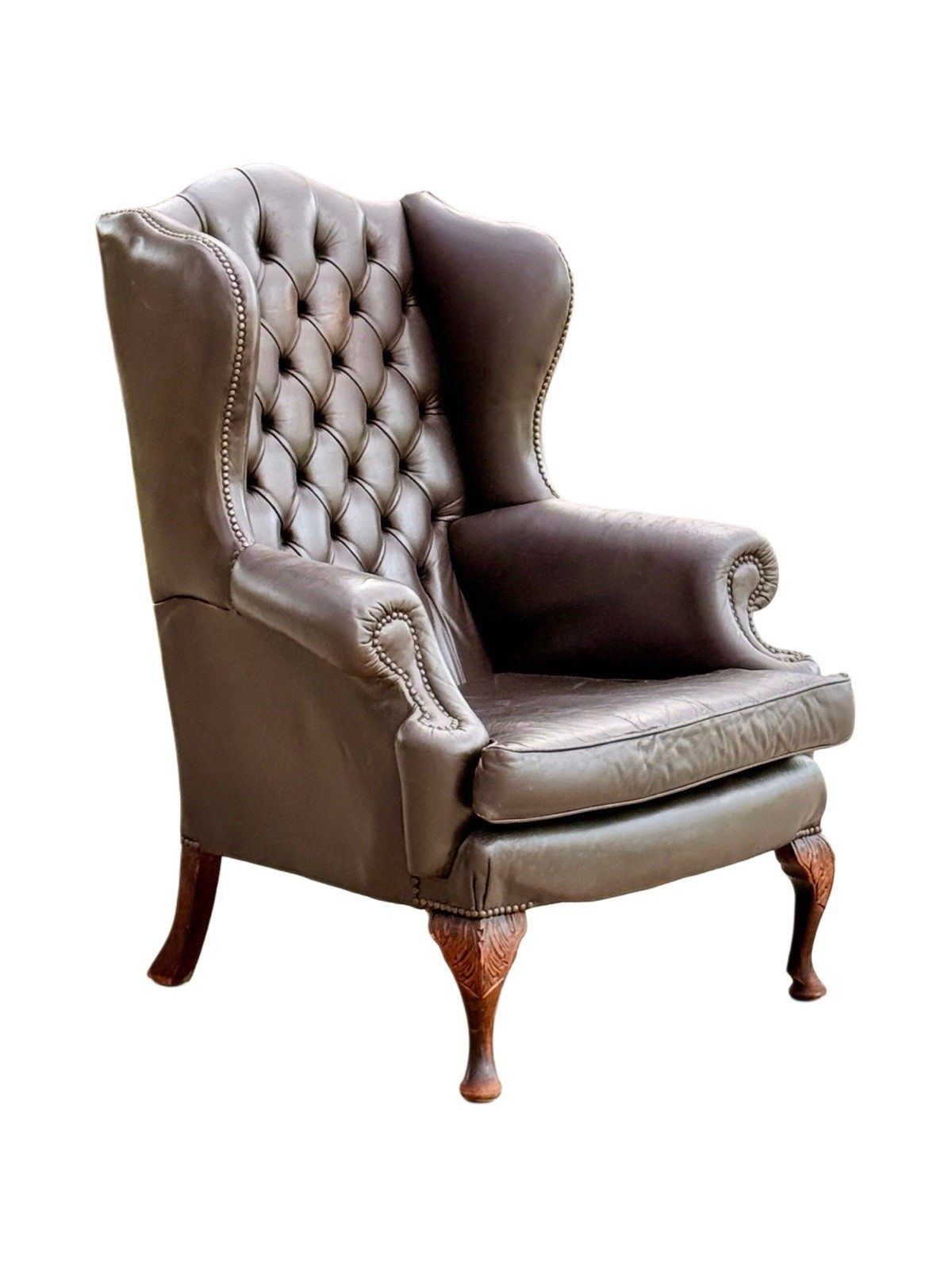 Vintage brown leather Chesterfield wingback armchair, deep buttoned, with rolled arms, brass nailheads and cabriole legs