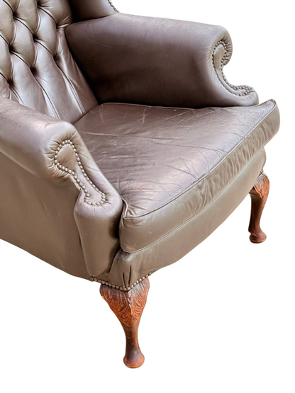 Close-up of rolled arm, seat cushion and carved cabriole leg