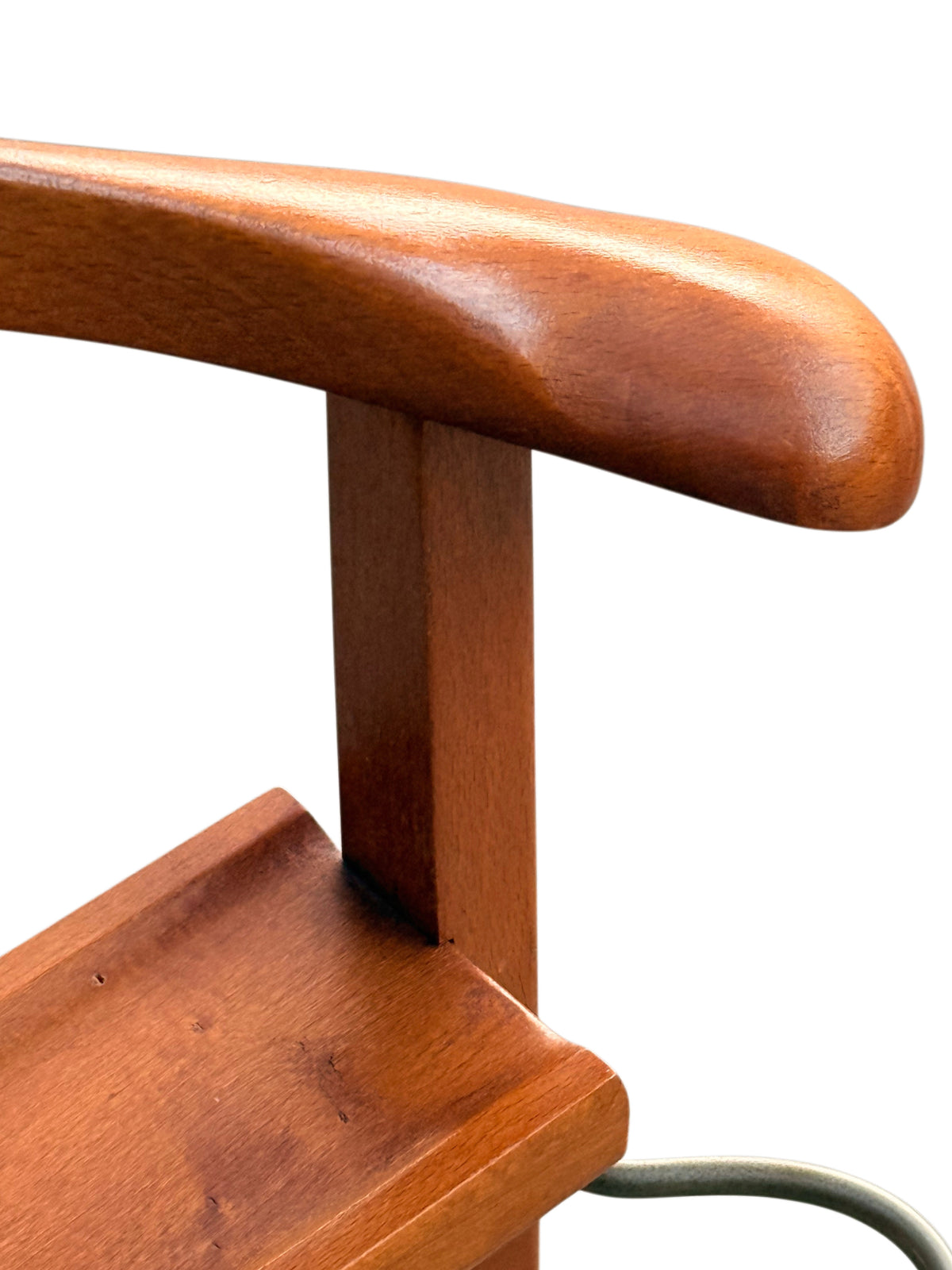 Close-up of the rounded hanger shoulder and accessory tray of the valet stand