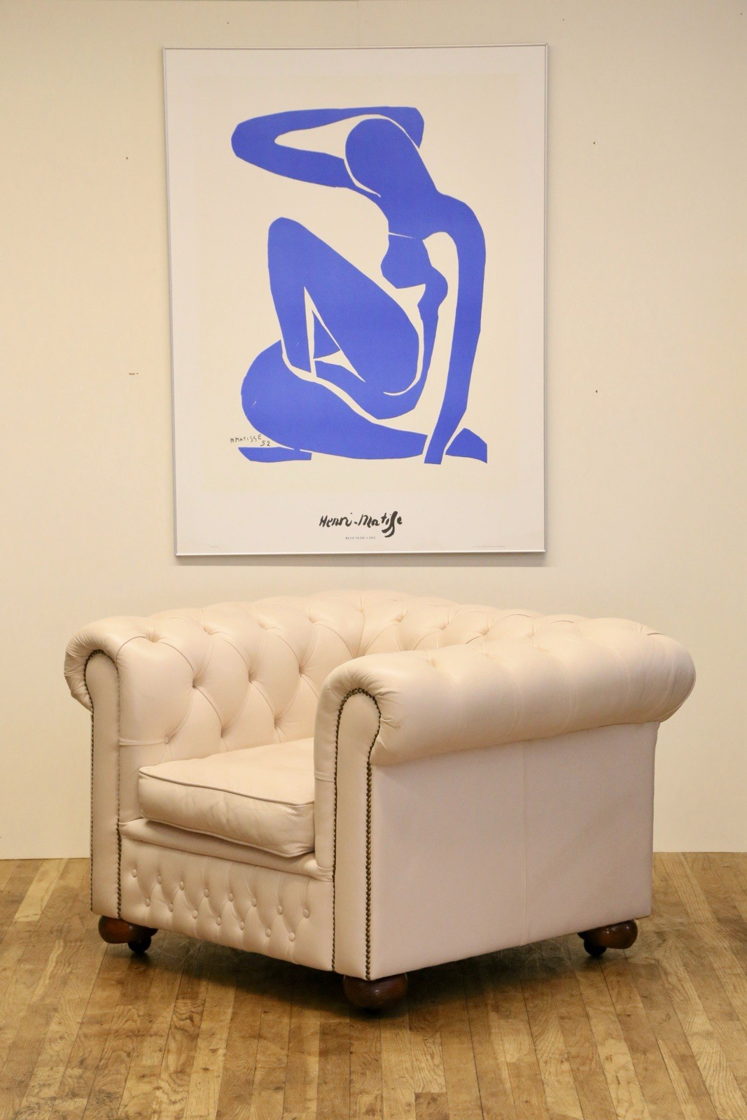 Vintage off-white leather Chesterfield club chair, angled view