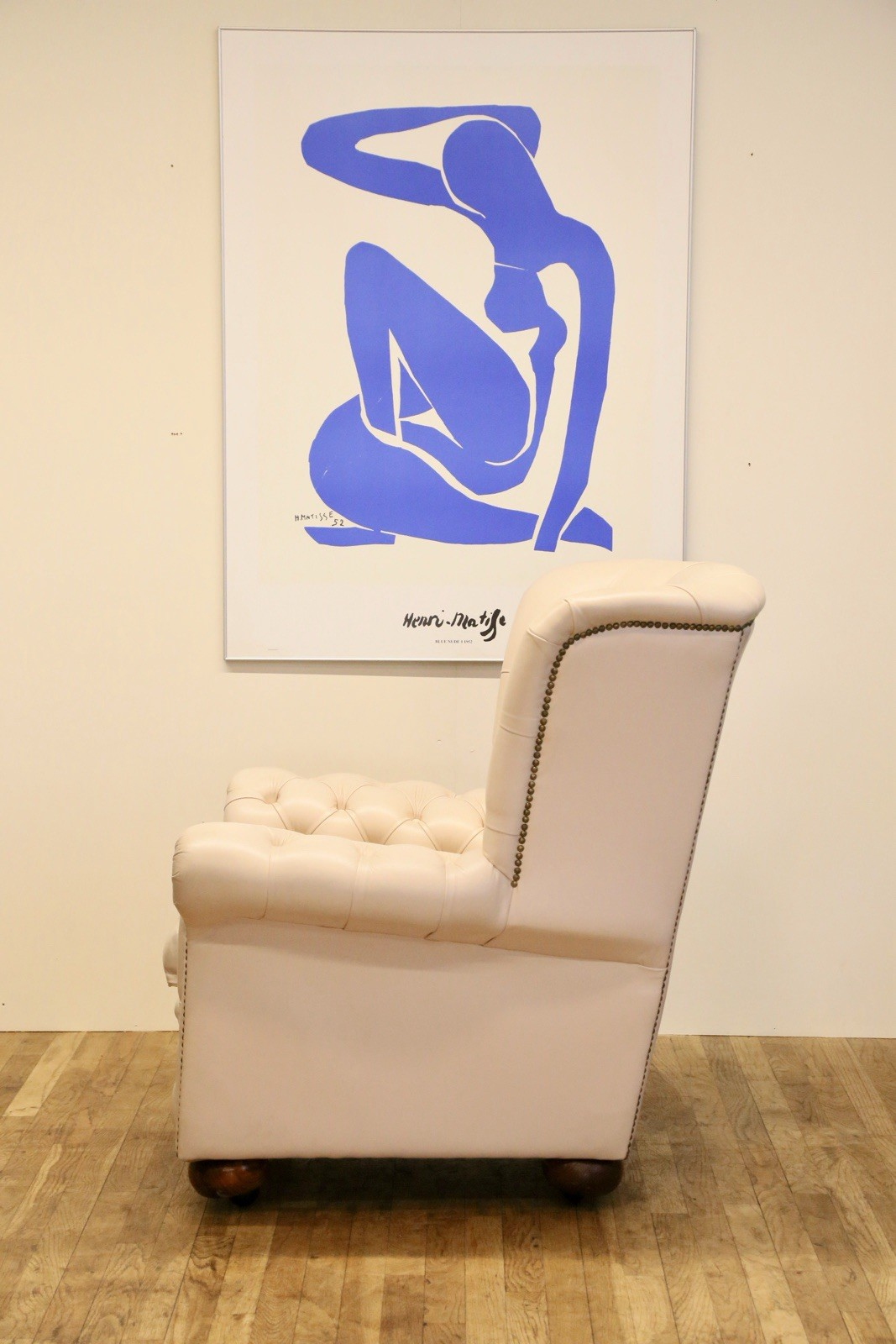 Vintage off-white leather Chesterfield wingback armchair, side view
